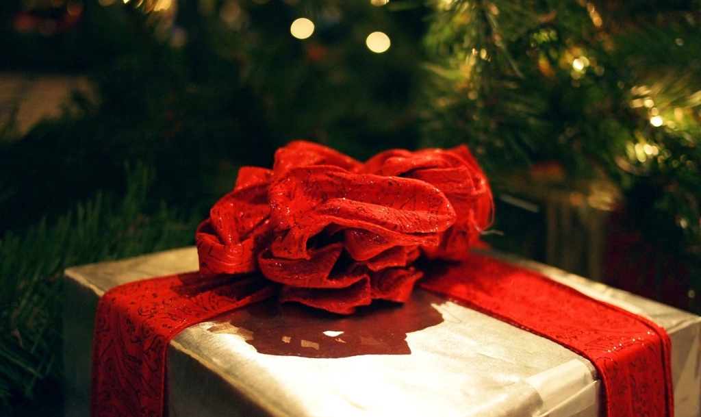 Holiday Gift wrapped with a red bow; Tips for pitching for holiday gift guides